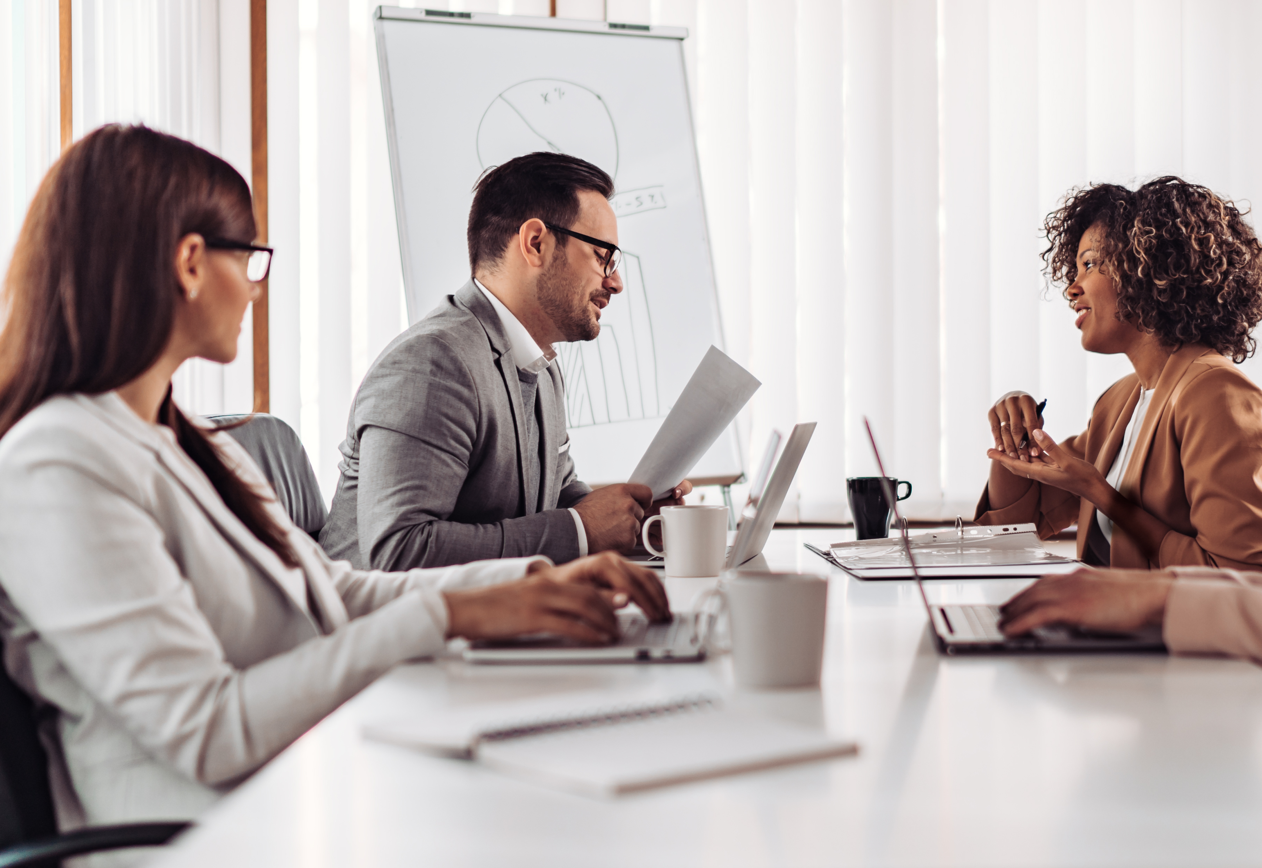 A group of people sitting at a table having a meeting